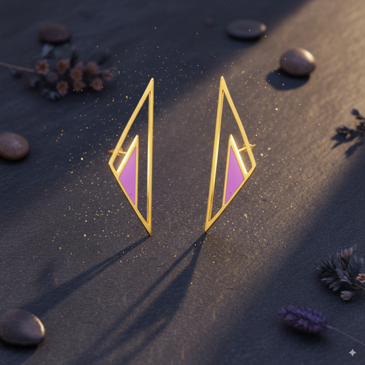 Gold and pink geometric earrings on a dark surface with stones and plants.