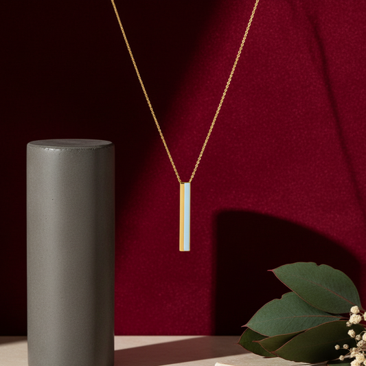 Gold necklace with a white pendant on a dark red background