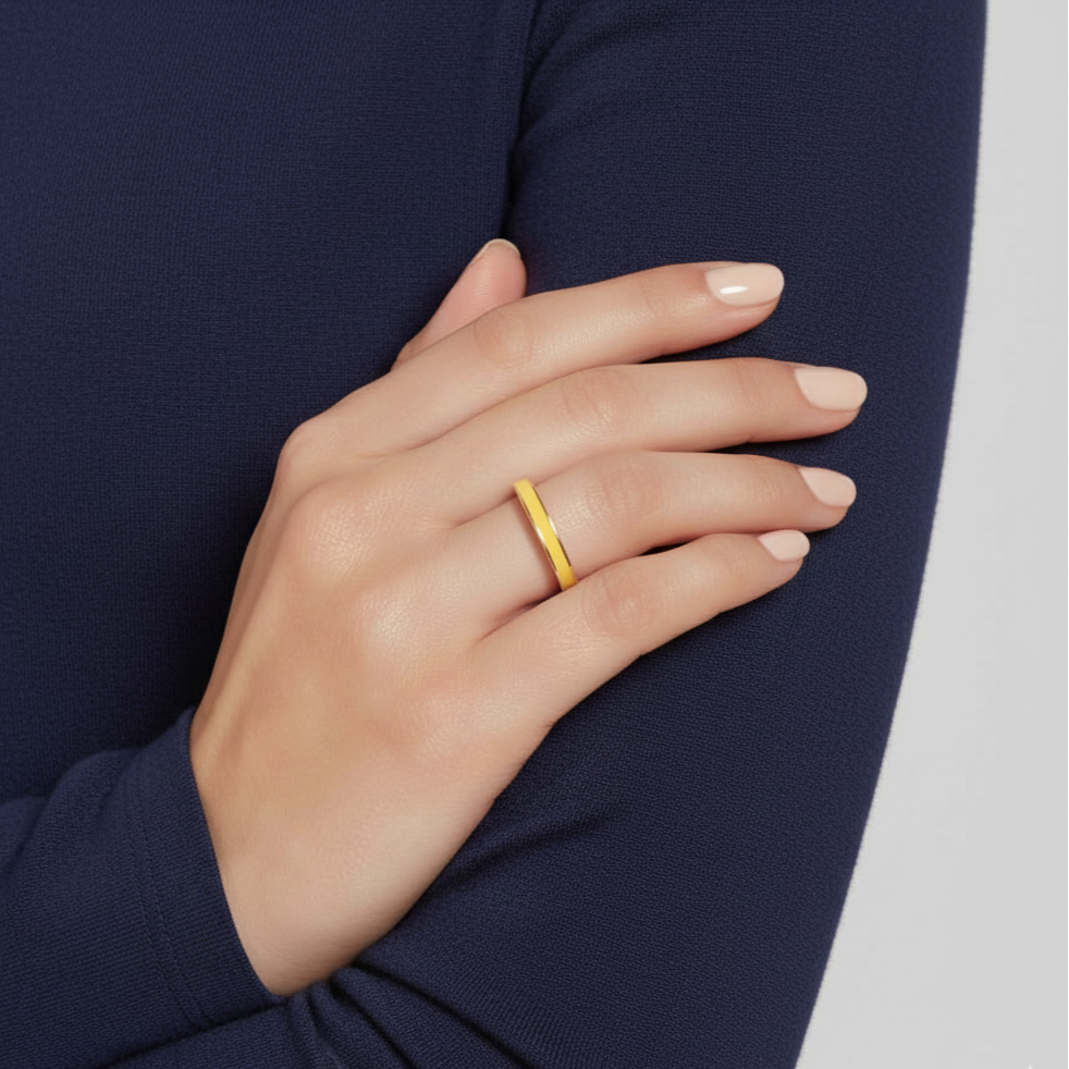 Hand wearing a gold ring on a navy sleeve with a white background