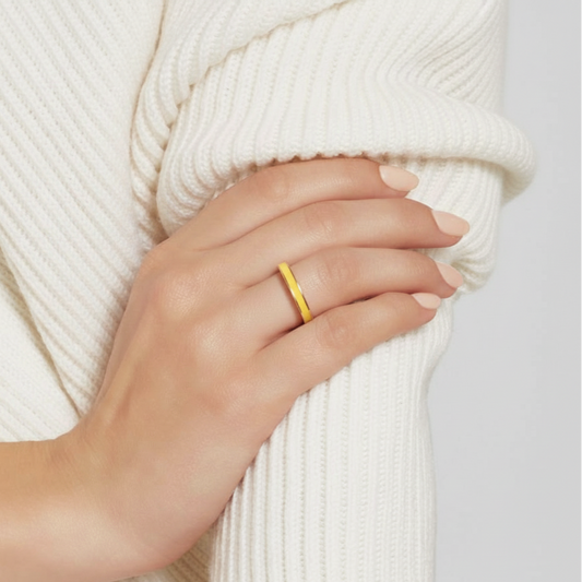 Hand wearing a gold ring on a white background
