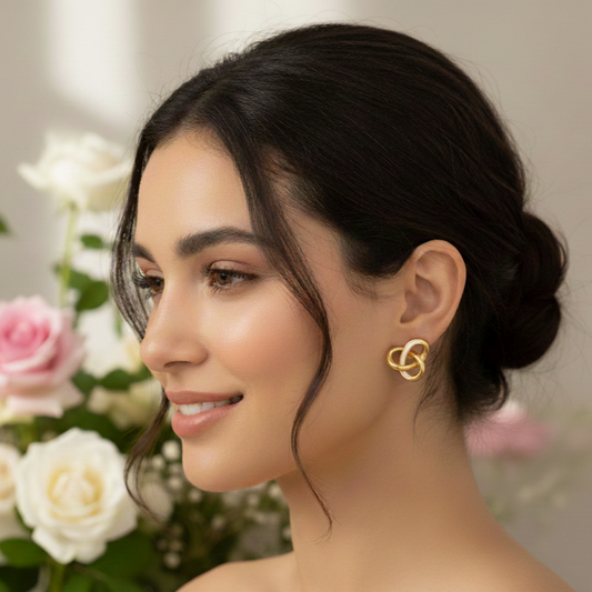 Woman wearing gold earrings with flowers in the background