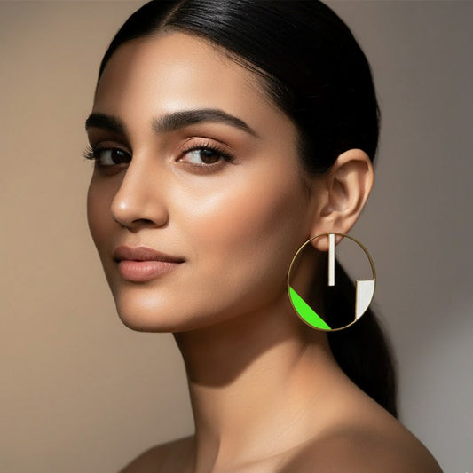 Woman wearing a hoop earring with a green accent on a neutral background