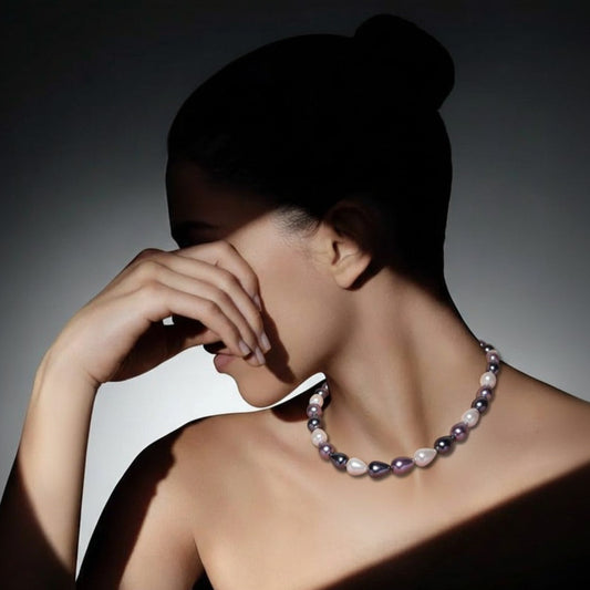 Woman wearing a pearl necklace with a dark background