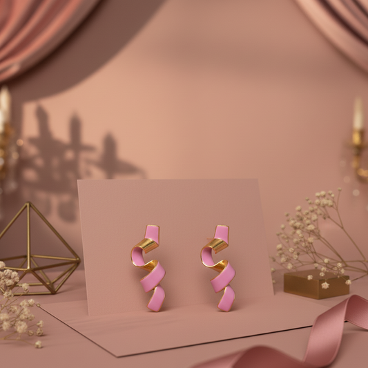 Pink and gold earrings on a pink card with a soft pink background